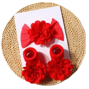 Red baby headband and socks set with large floral bows on natural woven background