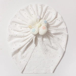 Close-up of white breathable hollow knit baby hat with macaron color floral embroidery