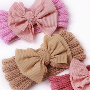 Nahaufnahme gestrickter Baby-Stirnbänder mit großen Schleifen in Rosa und Khaki