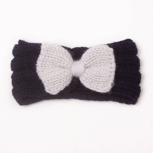 Dettaglio di una fascia per neonati in maglia blu scuro con fiocco bianco per bambini