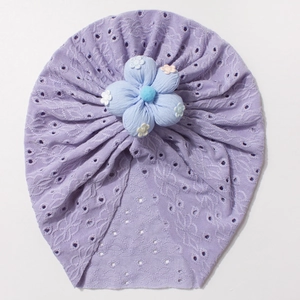 Detail of purple infant turban hat with eyelet fabric and a large blue fabric flower