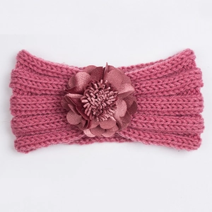Detailed close-up of rose red knitted baby headband with a large layered satin flower decoration