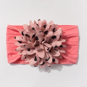 Pink jacquard nylon baby headband with a large polka dot flower ornament for infants