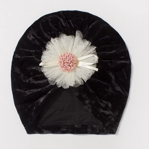 Detail of baby velvet hat with large white lace flower and decorative pink center
