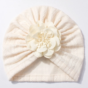 Détail du turban pour bébé crème avec une fleur 3D décorative et une texture en tricot fin