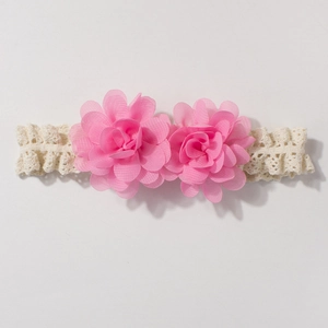 Detailed view of pink chiffon double flowers on an ivory lace baby headband for infants