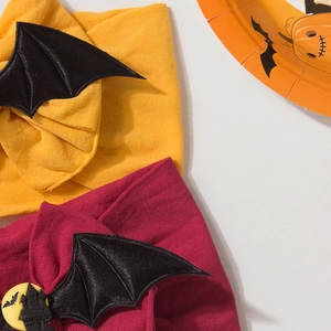 Detail shot of Halloween baby headband with bat wings and moon themed circular charms