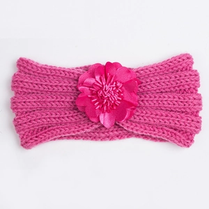 Detail of rose red knitted baby headband featuring a large satin layered flower ornament