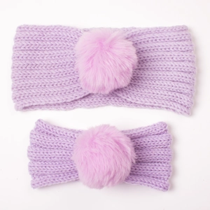 Detail view of purple knitted mother and baby headbands with pink faux fur pom poms