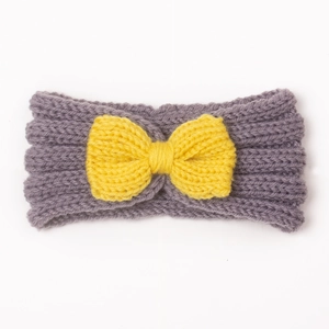 Dettaglio della fascia per neonati in maglia grigio scuro con un fiocco giallo