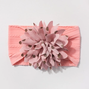 Detail of pink ribbed nylon baby headband featuring a large polka dot fabric flower charm