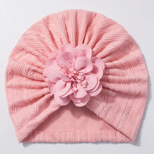 Détail du bonnet turban rose pour bébé avec maille chevrons douce et grande fleur décorative