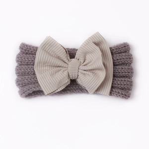 Detailaufnahme von grauem Strick-Stirnband mit großer beige Schleife für Babys
