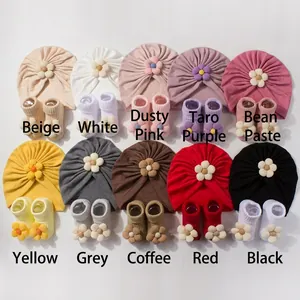 Flat lay of cotton baby hat and sock sets in ten various colors for newborns