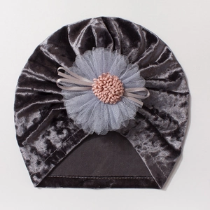 Detail view of dark grey velvet baby turban hat with mesh flower and pink pompom