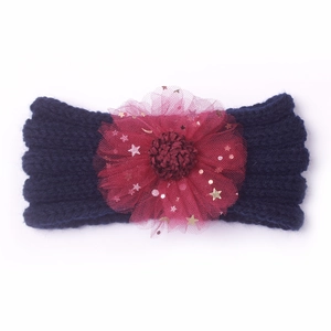 Détail du bandeau tricoté pour bébé avec fleur en tulle bordeaux et paillettes dorées