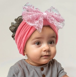 Détail du bandeau rose pour bébé avec grand nœud en dentelle et tissu nylon élastique