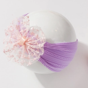 Détail du bandeau bébé en tricot violet avec grande fleur en dentelle de tulle rose