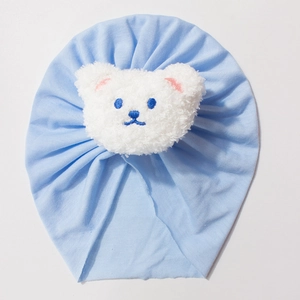 Light blue baby turban hat featuring a soft white plush bear patch for infants