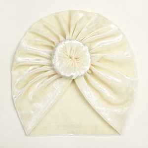 Close-up detail of cream white velvet baby donut hat with soft plush texture
