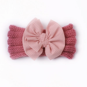 Detail eines weich gestrickten Baby-Stirnbands mit großer Schleife in Altrosa