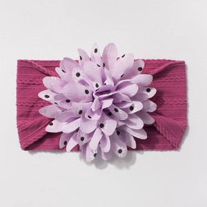Close-up of pink jacquard nylon baby headband with a large purple polka dot fabric flower