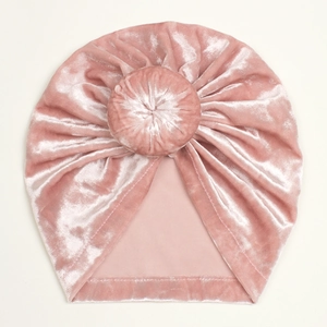 Macro shot of soft pink velvet baby turban hat with a signature donut knot detail
