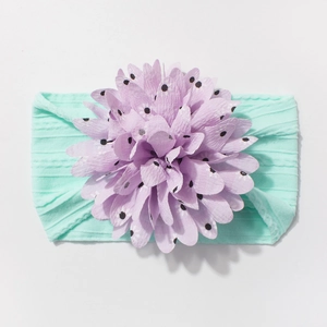 Detail of baby nylon headband featuring a purple polka dot 3D flower and mint green rib band