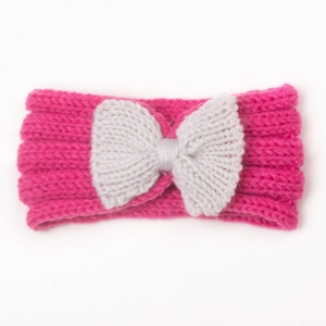 Dettaglio macro della fascia in maglia rosa per neonati con fiocco color crema