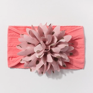Detail of baby headband with pink ribbed fabric and brown polka dot flower pattern