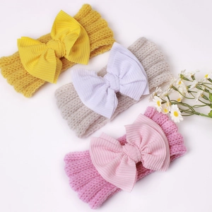 Three-pack of warm knitted baby headbands with large bows in yellow, cream, and pink colors