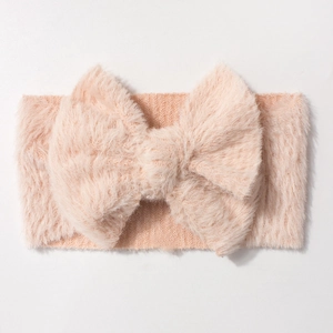 Detail of soft plush bow baby headband in pink orange fluffy fabric texture
