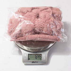 Detailed close-up showing the weight of 64.9g for the pink plush baby scarf set