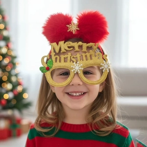 Close-up of kids Christmas headband with gold Merry Christmas glasses and red fluffy pom-poms