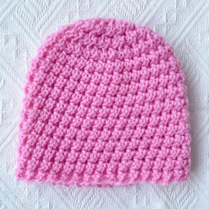 Pink chunky knit beanie for infants and toddlers with warm crochet texture and round crown