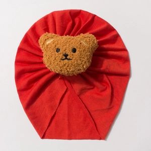 Breathable red cotton knit baby beanie featuring a cute plush bear decoration