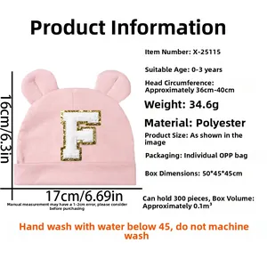 Detailed view of pink baby hat with bear ears, sequined letter F, and product dimensions