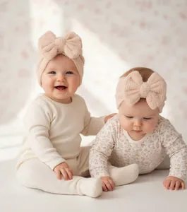 Close-up of baby girl wearing soft plush headband and hat with large bow detail