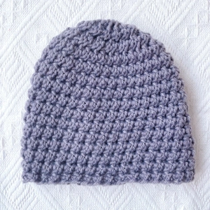 Detailed macro view of purple thick knit texture on a warm winter baby beanie hat
