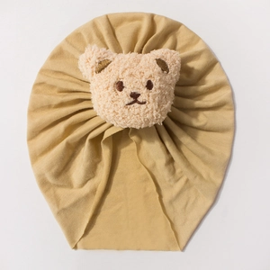 Ginger yellow baby turban hat with soft plush bear patch and pleated cotton fabric