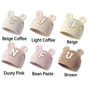 Detail view of colorful modal baby beanies with cute ears and letter prints in six shades