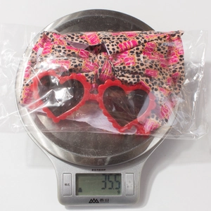 Bandeau léopard bébé et lunettes cœur pesant 35,5g dans un emballage plastique scellé