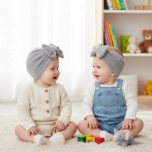 Close-up of soft gray knit baby hat and headband set with decorative bows on models