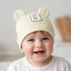 Close-up of soft modal baby beanie featuring cute ears and sequined letter B embroidery