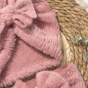 Detail of pink plush baby hat set with large bow and soft ribbed knit texture lining