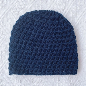 Detailed knit texture of dark blue winter baby beanie made of thick acrylic blend yarn