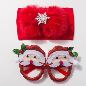 Detailed view of red fur bow headband and Santa Claus glitter glasses for Christmas