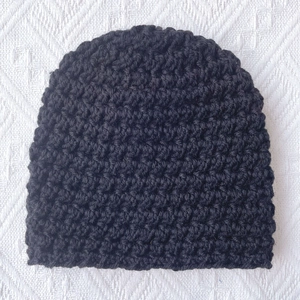 Detailed macro view of black chunky knit baby beanie texture for winter warmth