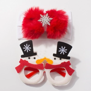 Close-up of baby Christmas headband with large red bow and snowman decorative glasses