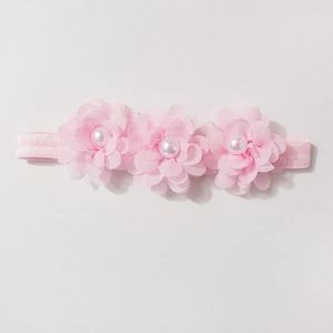 Détails de fleurs en mousseline rose et perles sur un bandeau élastique pour bébé